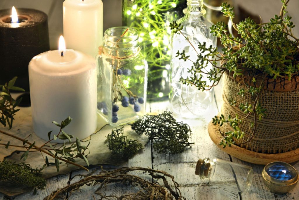 Faelorin Herbs, roots, berries and burning candles on witch table Herbs, roots, berries and burning candles on witch table