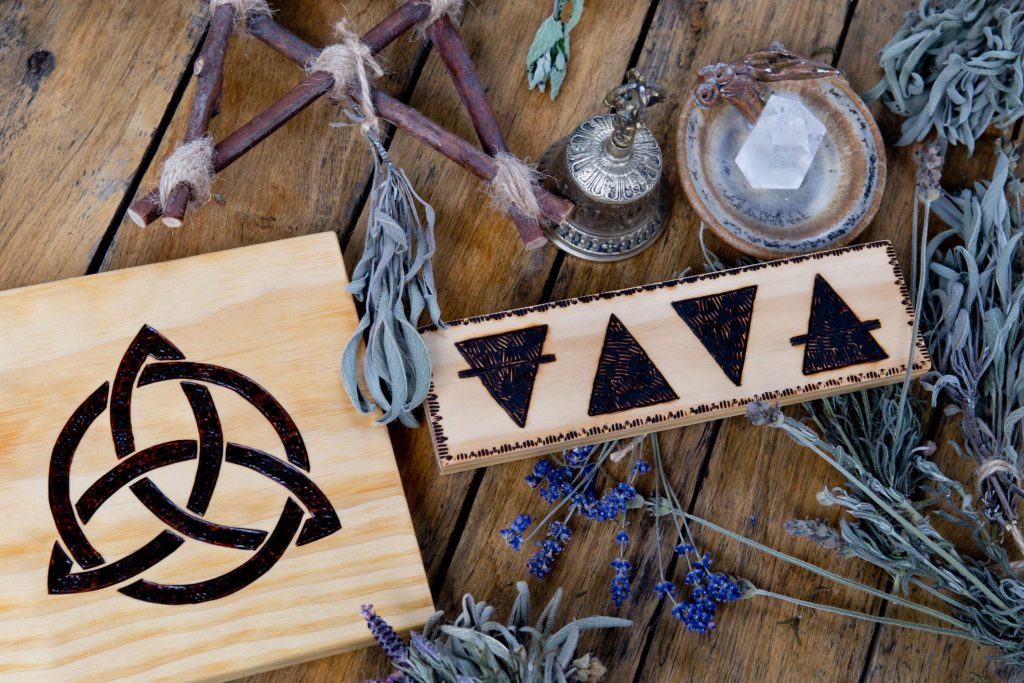 Earth Wind Fire Water symbols and Dried Flowers on Wooden Table