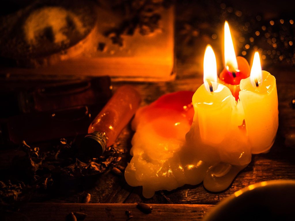 Faelorin | Candles burning in the dim light Faelorin Store | Three candles burning low in a darkened room.